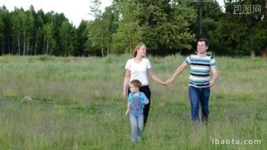 年轻的父母和他们的儿子走在草地上男人和女人牵着手